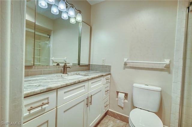 bathroom with toilet, vanity, and decorative backsplash