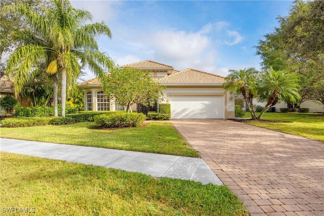 mediterranean / spanish-style house featuring a garage and a front lawn