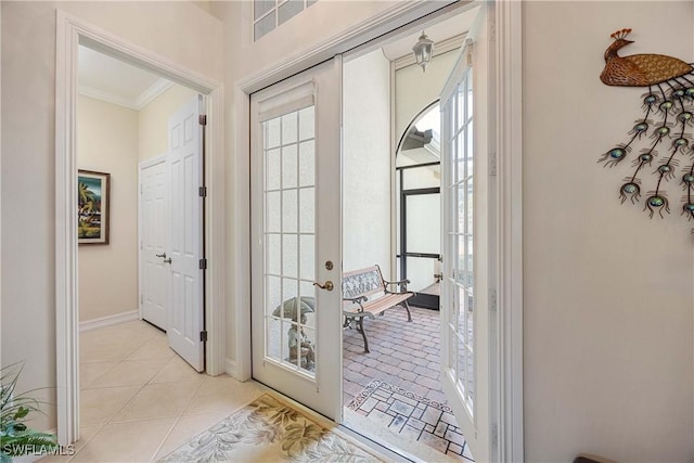 entryway featuring crown molding, french doors, and light tile patterned flooring