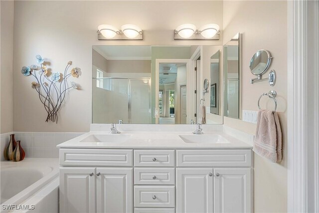 bathroom featuring independent shower and bath, vanity, and ornamental molding