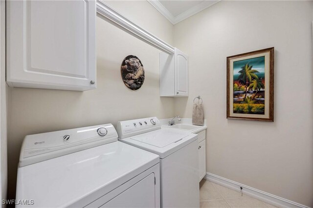 laundry area with cabinets, ornamental molding, sink, and washer and dryer