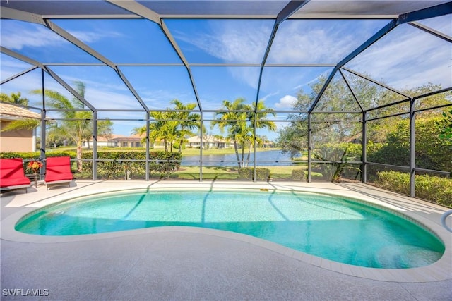 view of swimming pool featuring a patio area, glass enclosure, and a water view