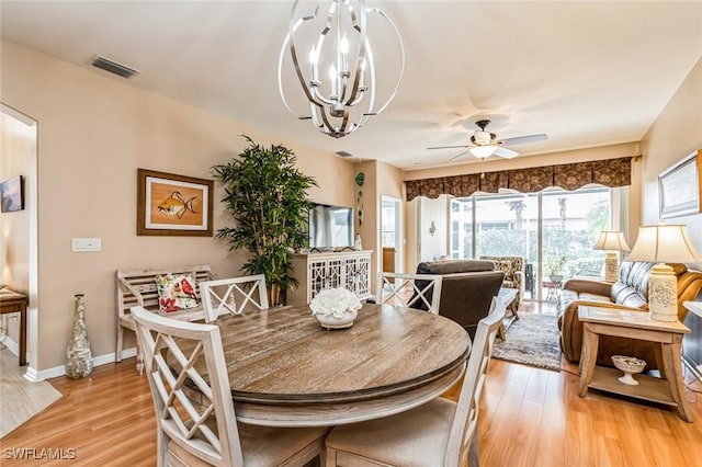 dining area featuring ceiling fan with notable chandelier and light hardwood / wood-style floors