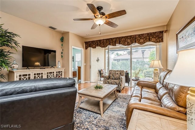 living room with wood-type flooring and ceiling fan