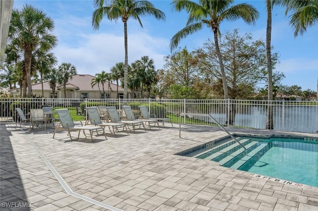 view of swimming pool featuring a water view and a patio