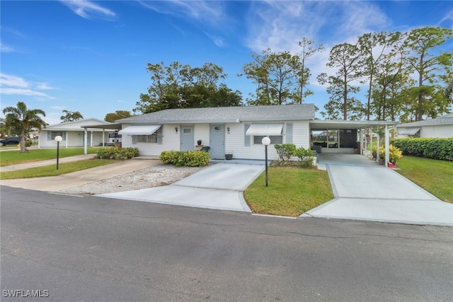 single story home featuring a front lawn and a carport