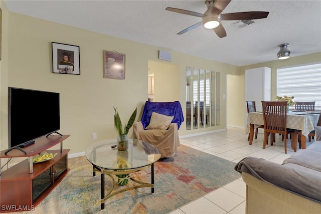 tiled living room with ceiling fan and a textured ceiling