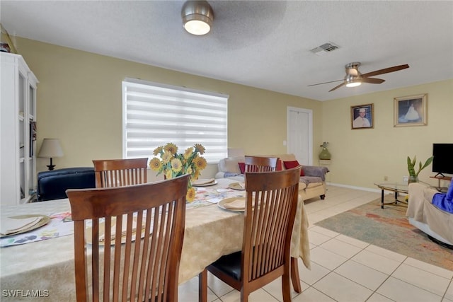 tiled dining area featuring ceiling fan and a textured ceiling