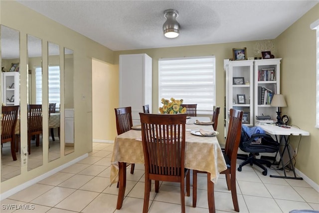 tiled dining area with a textured ceiling