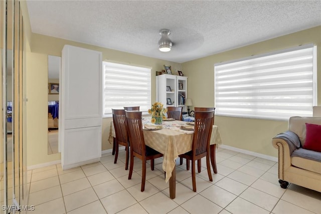 tiled dining room featuring a textured ceiling