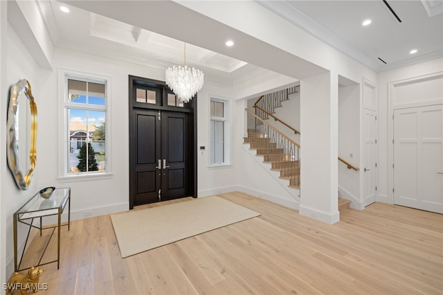 foyer featuring an inviting chandelier, hardwood / wood-style floors, and crown molding