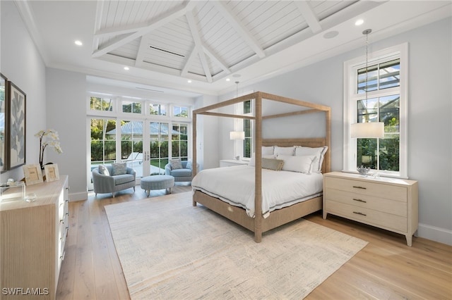 bedroom featuring beam ceiling, light hardwood / wood-style floors, and multiple windows