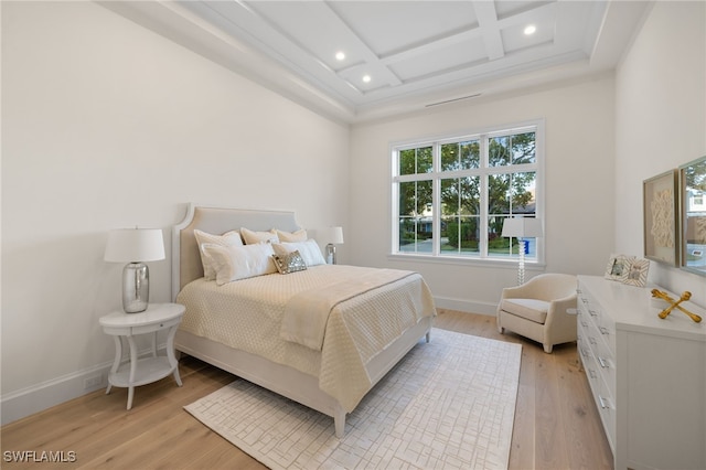 bedroom featuring coffered ceiling, beam ceiling, and light wood-type flooring