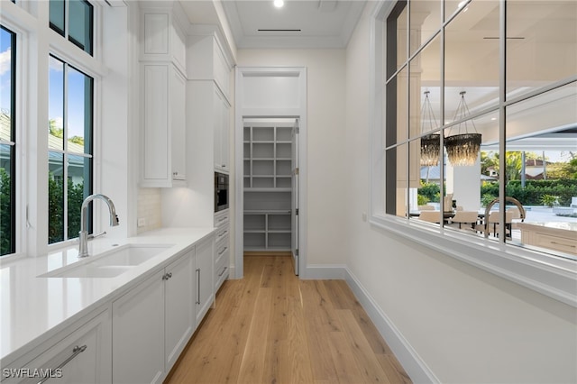 interior space with sink, an inviting chandelier, and light hardwood / wood-style flooring