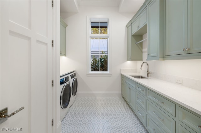 clothes washing area featuring cabinets, sink, and washing machine and clothes dryer