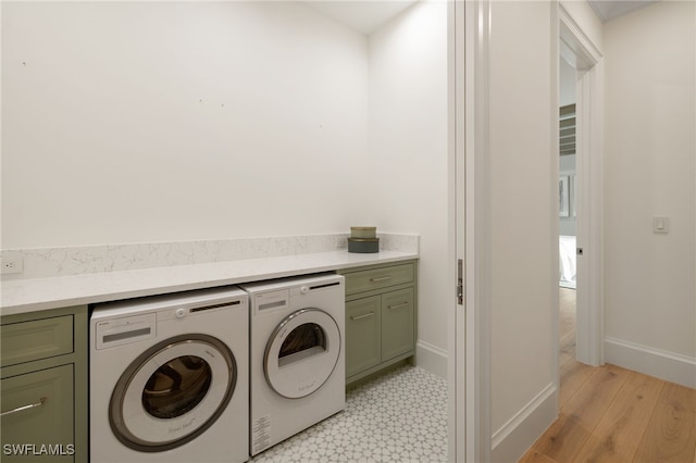 laundry room with independent washer and dryer and cabinets