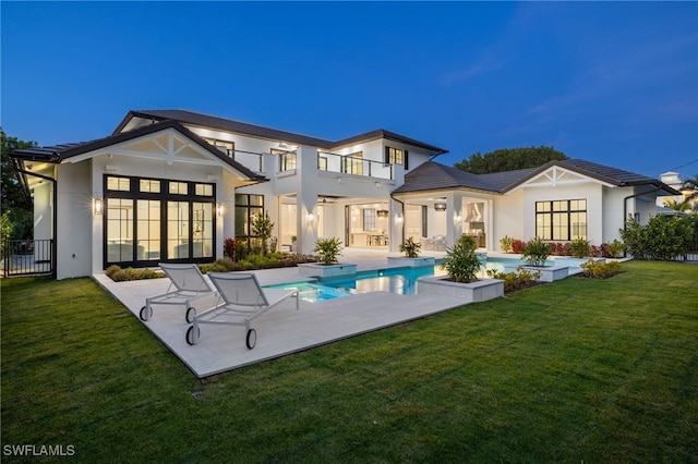 460 2nd Ave N, Naples, FL 34102 - back of property featuring a balcony, a yard, a patio area, stucco siding, and a pool with connected hot tub