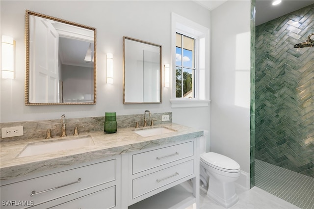 bathroom featuring vanity, toilet, and tiled shower