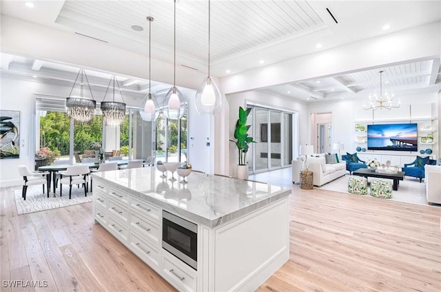 460 2nd Ave N, Naples, FL 34102 - kitchen featuring stainless steel microwave, a chandelier, light wood finished floors, white cabinets, and light stone countertops