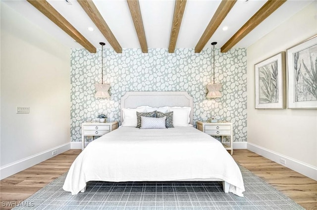 460 2nd Ave N, Naples, FL 34102 - bedroom featuring wallpapered walls, an accent wall, baseboards, wood finished floors, and beam ceiling