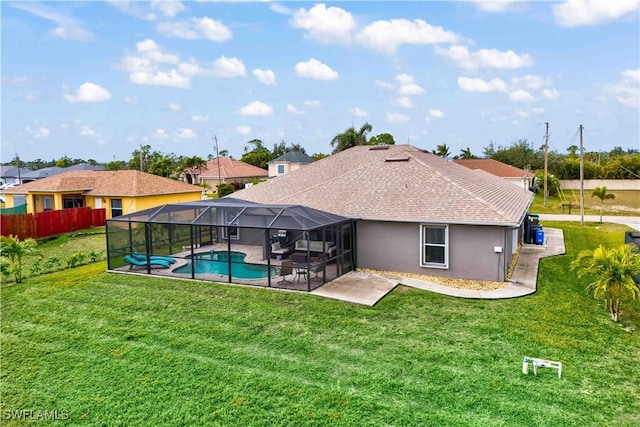 rear view of house with a fenced in pool, a lawn, a patio, and glass enclosure