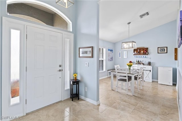 foyer entrance featuring lofted ceiling and a chandelier