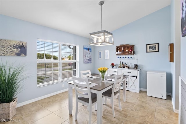 dining room with vaulted ceiling, light tile patterned floors, and a chandelier