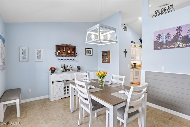 dining room featuring a notable chandelier and high vaulted ceiling