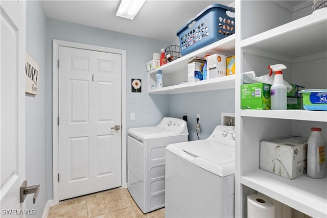 clothes washing area with light tile patterned floors and washer and dryer