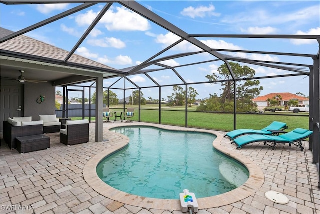 view of pool featuring a lawn, a lanai, ceiling fan, an outdoor living space, and a patio