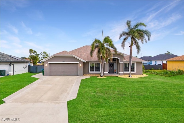 ranch-style home with a garage, a front yard, and central AC unit