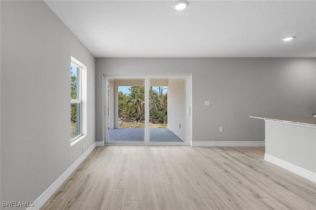 337 Woodburn Dr, Lehigh Acres, FL 33972 - unfurnished living room featuring light wood finished floors, baseboards, and recessed lighting