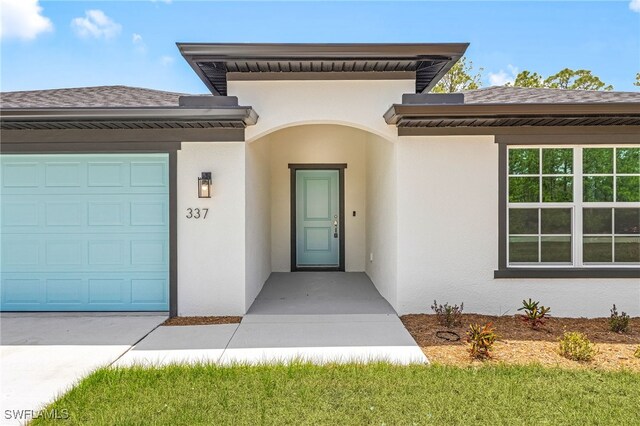337 Woodburn Dr, Lehigh Acres, FL 33972 - view of exterior entry featuring stucco siding and an attached garage