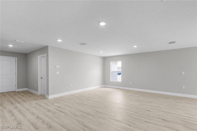 337 Woodburn Dr, Lehigh Acres, FL 33972 - empty room with light wood-style flooring, baseboards, recessed lighting, and a textured ceiling