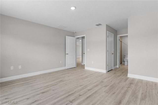 337 Woodburn Dr, Lehigh Acres, FL 33972 - unfurnished bedroom with light wood-style floors, baseboards, recessed lighting, and ensuite bathroom
