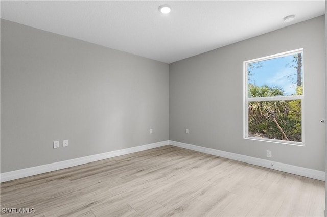 337 Woodburn Dr, Lehigh Acres, FL 33972 - empty room featuring light wood finished floors, a smoke detector, and baseboards