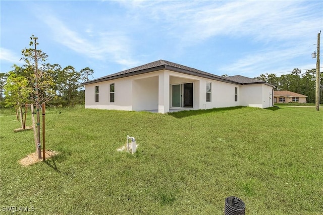 337 Woodburn Dr, Lehigh Acres, FL 33972 - rear view of house with a yard and stucco siding