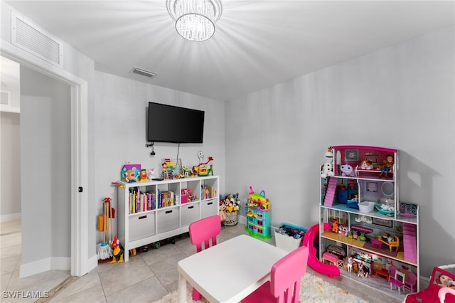 playroom featuring light tile patterned floors and an inviting chandelier