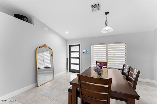 dining space with light tile patterned floors and lofted ceiling