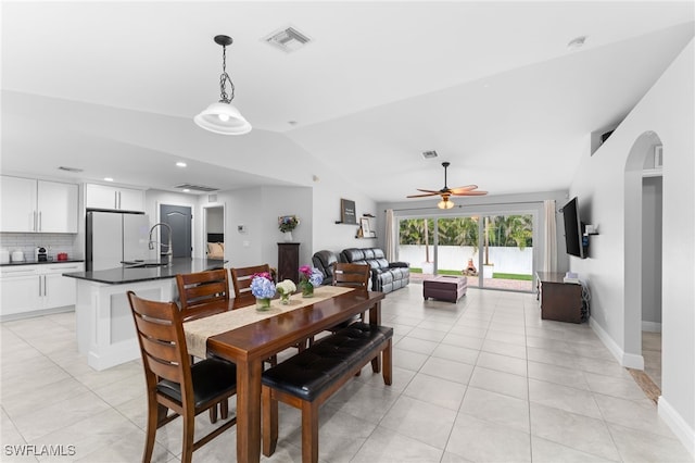 dining room featuring sink, vaulted ceiling, ceiling fan, and light tile patterned floors