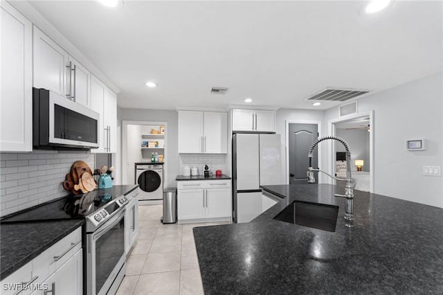 kitchen with white cabinets, white fridge, washer / clothes dryer, and stainless steel electric stove