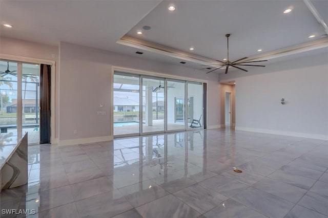 unfurnished room with a raised ceiling and ceiling fan