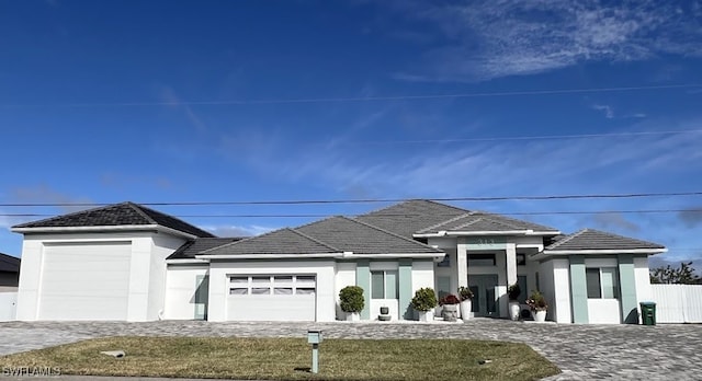 prairie-style home with a garage and a front yard