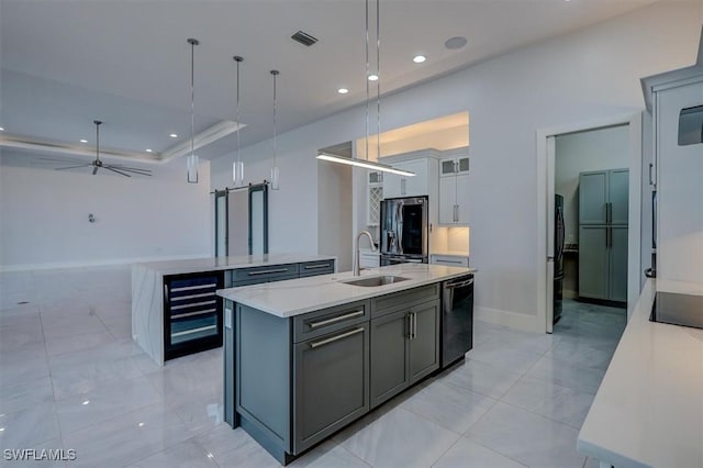 kitchen featuring decorative light fixtures, sink, wine cooler, a kitchen island with sink, and black appliances