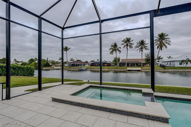 view of swimming pool featuring an in ground hot tub, a water view, a patio area, and glass enclosure