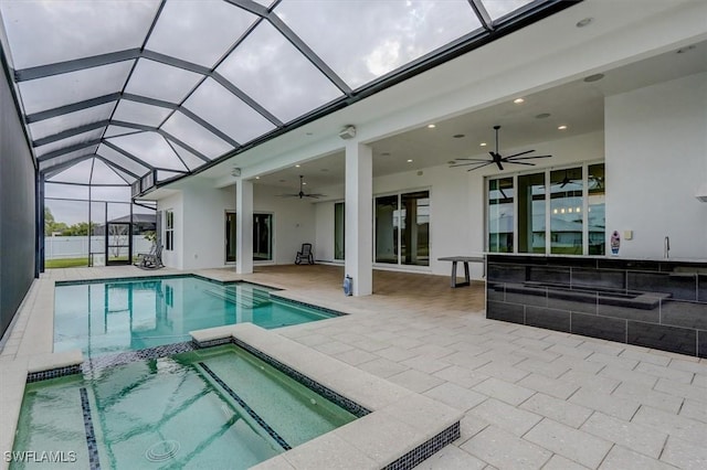 view of swimming pool featuring an in ground hot tub, a lanai, ceiling fan, and a patio area