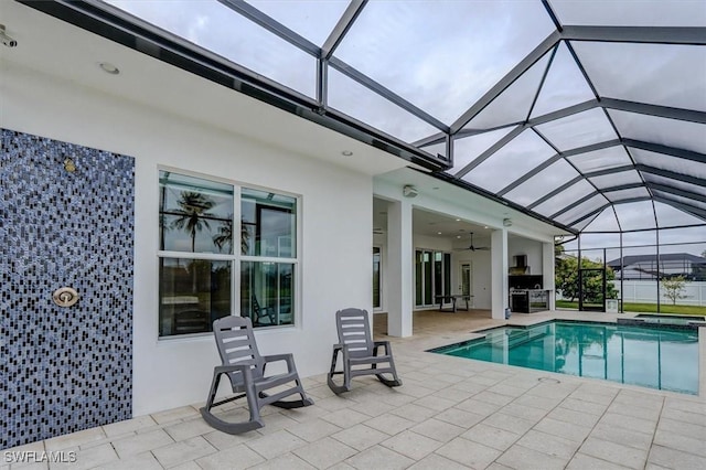 view of swimming pool featuring ceiling fan, glass enclosure, and a patio area