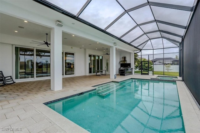 view of swimming pool featuring an in ground hot tub, ceiling fan, a patio, and glass enclosure