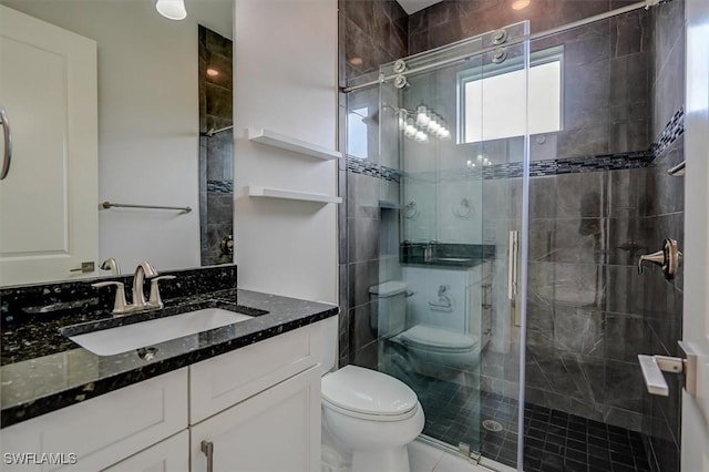 bathroom featuring vanity, walk in shower, and toilet