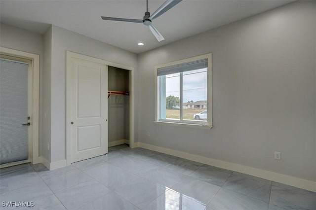 unfurnished bedroom with ceiling fan and a closet